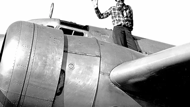 La aviadora saluda apoyada en el fuselaje del 'Lockheed', con el que intentó dar la vuelta al mundo.