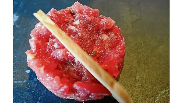 Sashimi de salmón sobre cebolla y tomate, tartar de atún rojo se sirve con otro de carne y canelón de rabo de toro.