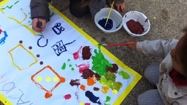 Los niños pintan murales, en una de las actividades de la Semana de la Infancia