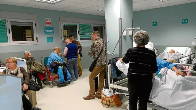 Uno de los pasillos del hospital, ayer, con enfermos esperando a ser atendidos.