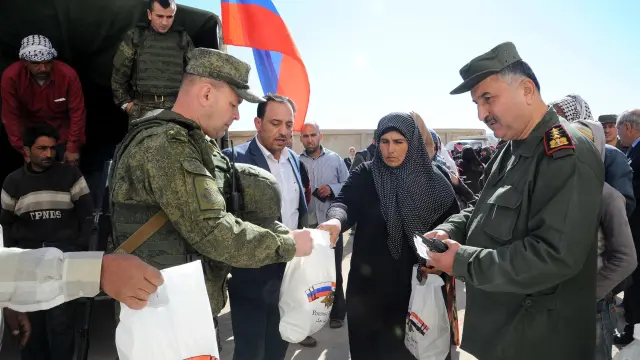 Sirios recibiendo ayuda humanitaria de soldados rusos