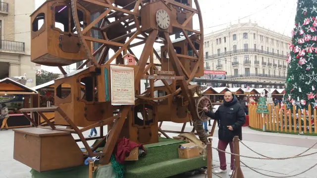 Julio César Villagram hace girar su noria de madera, en la plaza del Pilar.