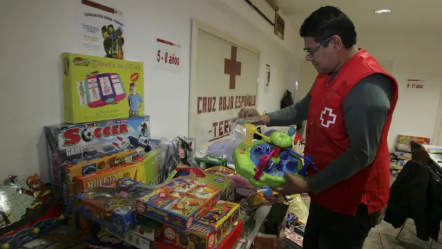 Un voluntario de Cruz Roja almacena los juguetes recogidos.