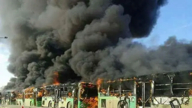 Algunos de los autobuses ardiendo.