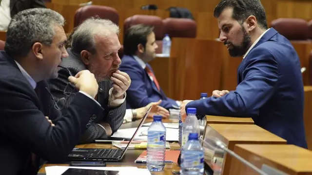 El portavoz del Grupo Parlamentario Socialista, Luis Tudanca (d), conversa con los procuradores Javier Izquierdo (i), y José Francisco Martín (c), durante la sesión plenaria de las Cortes