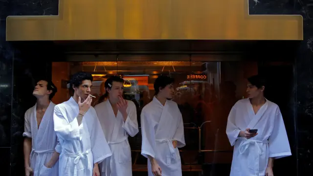 Un grupo de modelos fuma a las puertas del hotel donde se celebran los desfiles