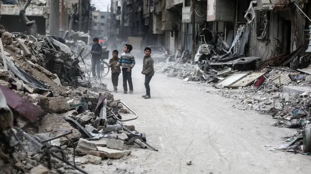 Varios niños sirios buscan entre los escombros de Alepo
