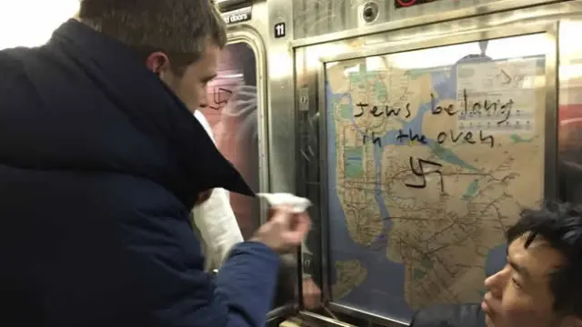 Un pasajero borra una pintada antisemita en el metro de Nueva York
