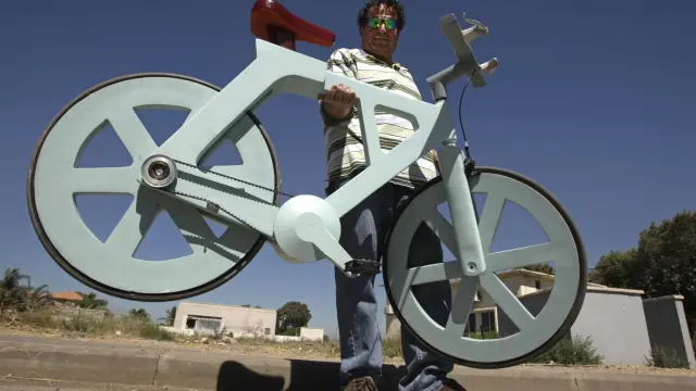 El ingeniero israelí Izhar Gafni sujeta su bicicleta de cartón.