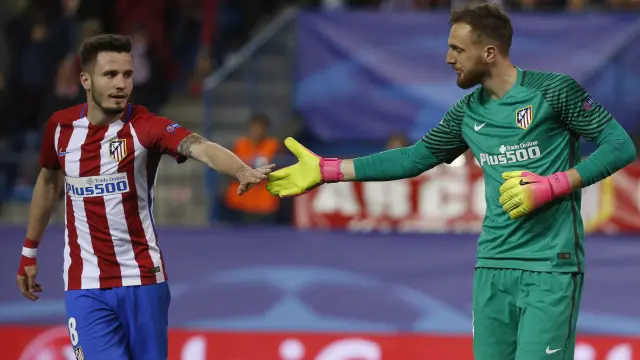 El centrocampista del Atlético de Madrid, Saúl Ñíguez -izda.-, felicita a su compañero, el guardameta esloveno Jan Oblak.