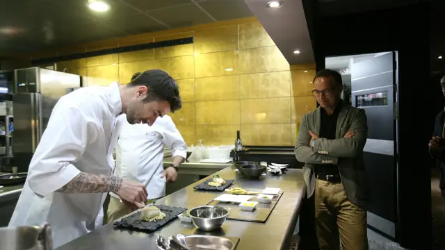 El jugador del Real Zaragoza, ultimando el taco de bacalao con arroz de coco, ante la atenta mirada de Christian Lapetra.