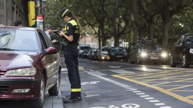 Una agente multa a un automovilista en el paseo de la Constitución de Zaragoza.