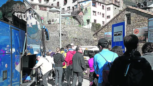 Varios turistas suben a los autobuses lanzaderas que van desde Torla al Paque.