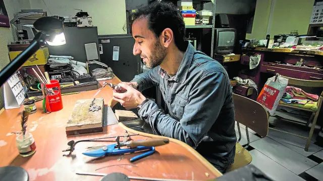 Santiago Jiménez arregla una joya en su negocio, situado en la avenida de San José.