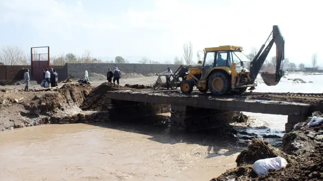 Trabajos para recomponer un puente desbordado por las aguas de un río debido a las inundaciones registradas en el norte de Irán, al sur de Tabriz.