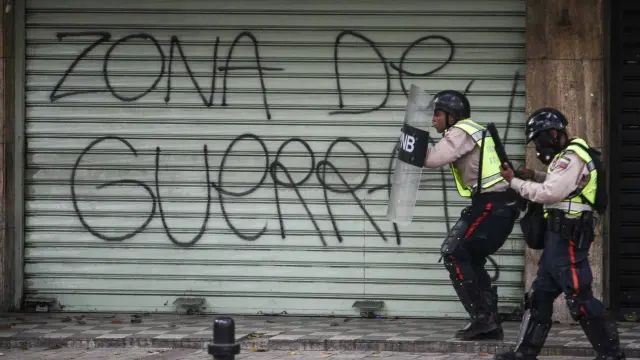 Agentes de la Policía Nacional Bolivariana bloquean el paso a una marcha opositora en Caracas.