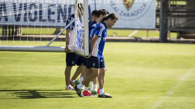 Varios jugadores del Real Zaragoza trasladan una portería móvil al inicio del entrenamiento.