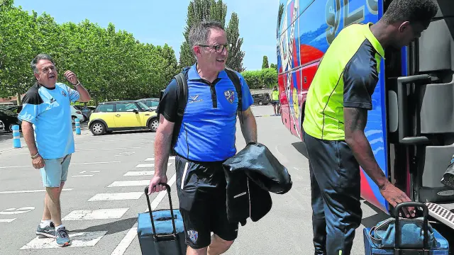 Anquela, técnico del Huesca, se dispone a entrar junto a Jair Amador en el autobús para viajar ayer a Valencia.