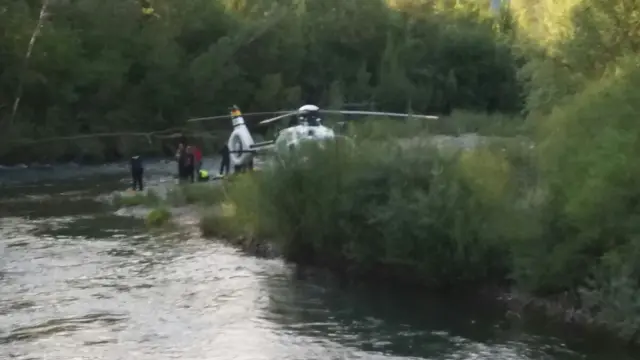 El helicóptero y socorristas de la Guardia Civil en el río.