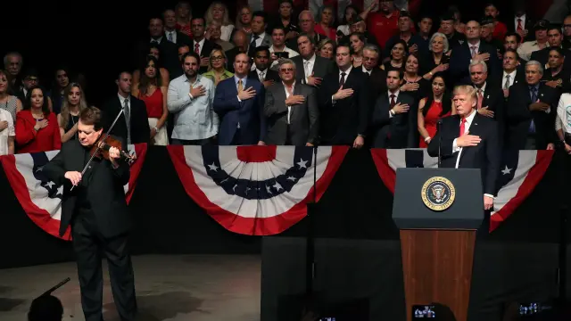 El presidente norteamericano escucha al violinista Haza tocar el himno nacional antes de anunciar el cambio en las relaciones con Cuba