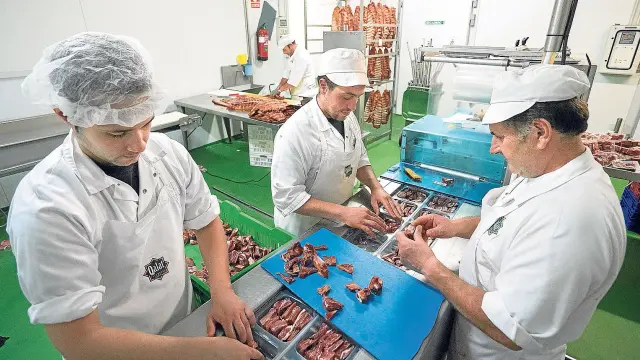 Un grupo de trabajadores de Cárnicas Santa Elena envasan productos de Denominación de Origen bajo la marca Qalat.