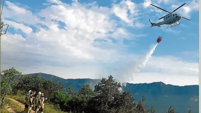Un helicóptero soltaba ayer agua para sofocar el incendio declarado durante la madrugada en Yesa.