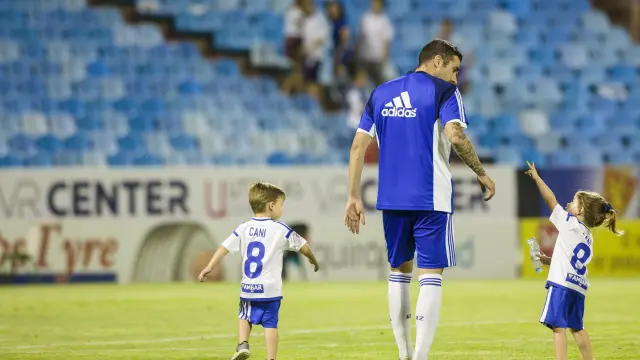 Cani, acompañado de sus hijos, sobre el césped de La Romareda tras el que ya es su último partido en el Zaragoza, contra el Tenerife.