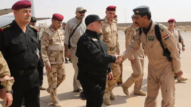 El primer ministro iraquí, Haider al Abadi, da la mano a un alto cargo del ejército.