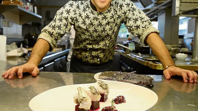Aitor Pérez, cocinero de Las Torres, de Huesca, con un plato de rape con anchoas, remolacha y vinagreta con cerezas.