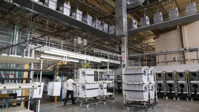 Un operario de la planta de BSH en La Cartuja empuja paneles frontales de lavadoras hacia las líneas de montaje.