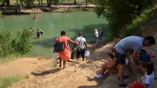 Algunos bañistas que acuden al salto de Bierge cruzan el río para encontrar el mejor sitio.