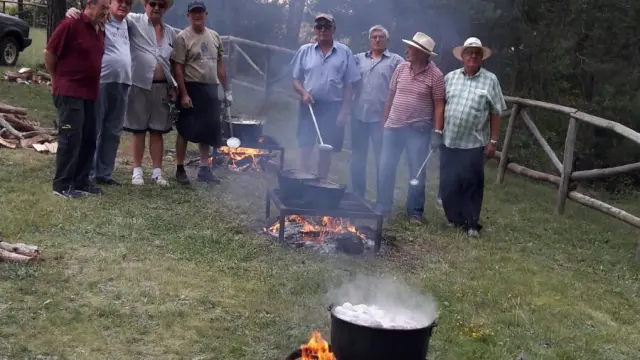 Un grupo de voluntarios prepara el suculento guiso.