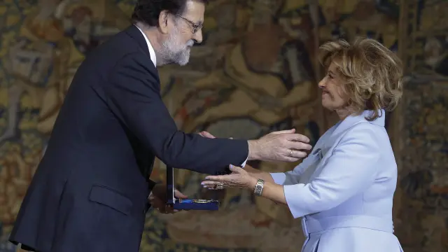 El presidente del Gobierno, Mariano Rajoy, entrega la medalla de oro al mérito en el trabajo a la periodista María Teresa Campos, este jueves.