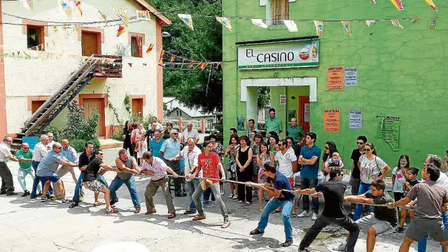 Vecinos de Lafortunada juegan al tiro de soga en las fiestas de la Vírgen de las Nieves.