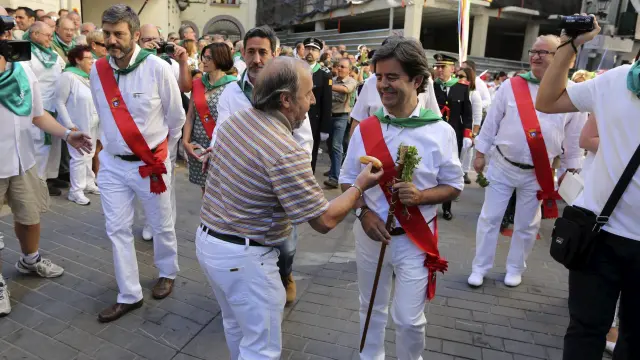 Un ciudadano ofrece un frito al alcalde de Huesca, Luis Felipe, al entrar en la plaza San Pedro.
