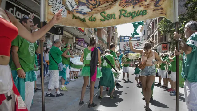 Peñistas de Los que faltaban, con sus camisetas verdes, junto a la charanga y a la pancarta.