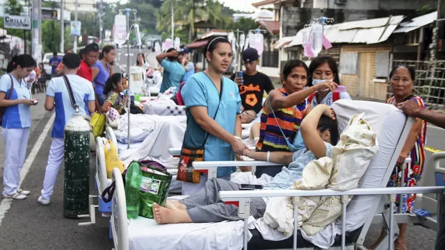Pacientes y personal sanitario a las puertas de un centro de evacuación tras el seísmo.