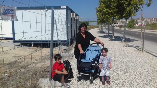 Rosana Rodríguez, con sus dos hijos, ante el solar del futuro colegio de Parque Venecia. Sus hijos estarán escolarizados en colegios diferentes por el retraso de las obras.