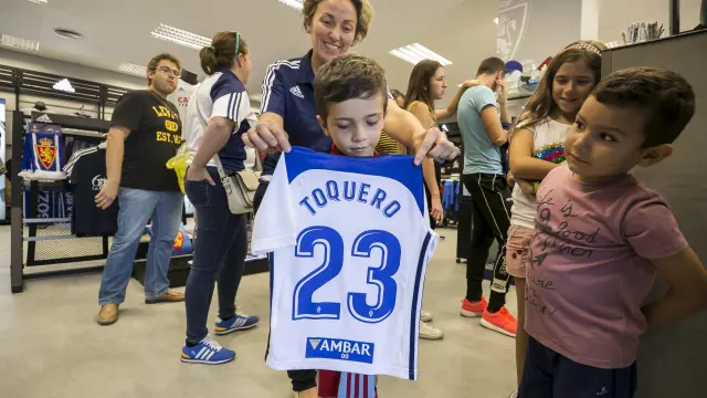 Un pequeño aficionado zaragocista muestra la camiseta de Toquero, ayer en la tienda del club.