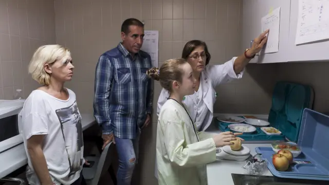 Carla con sus padres y una de las enfermeras que le ha enseñado a afrontar su enfermedad.