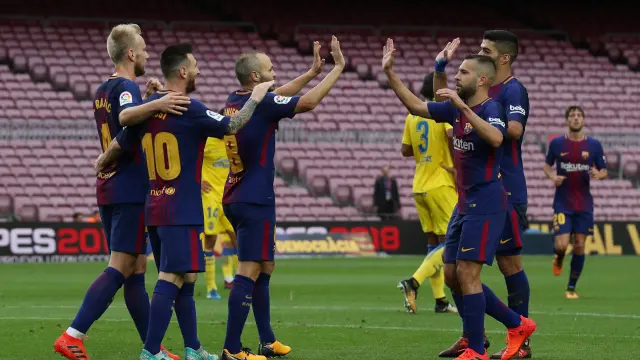 Los futbolistas del Bacelona celebran un gol con el Camp Nou vacío.
