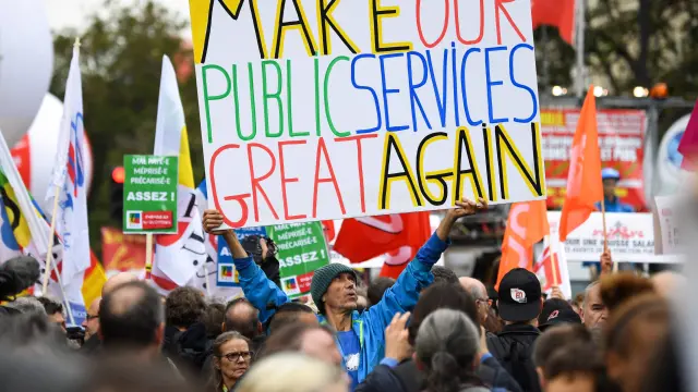 "Haz nuestros servicios públicos grandes otra vez", reza una pancarta en la manifestación de este martes en París.