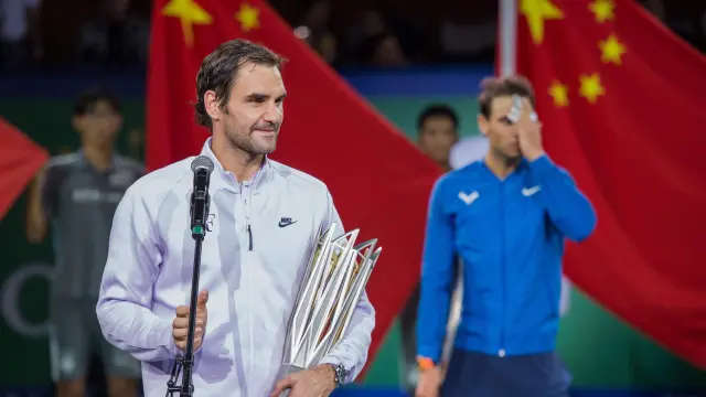 Federer, en primer plano, se dirige al público tras derrotar a Nadal, al fondo de la imagen.