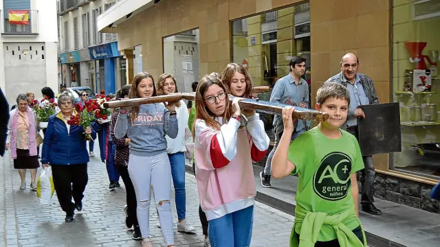 Un grupo de jóvenes lleva la Cruz de Lampedusa por las calles de Calatayud.