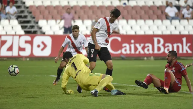 Verdasca y Cristian Álvarez por los suelos en el momento en el que Carlos Fernández, de rebote y de tacón, se aprovecha para anotar el 1-0 a favor del Sevilla Atlético.