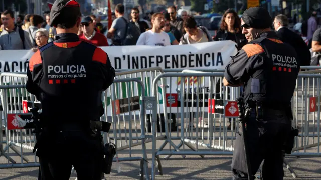 Dos mossos vigilan la concentración de personas que van llegando ante el Parlament este viernes.