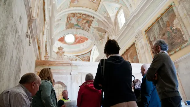 Visitantes en la Cartuja de Monegros, observando las pinturas interiores.