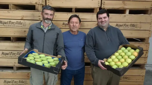 Los fruticultores Javier Nicolas (i), de BioPontil, y Miguel Pérez, de Cámaras Miguel (d), junto a José Luis Barraqueta, directivo del Épila, con las bandejas de fruta que se repartieron en el último partido.