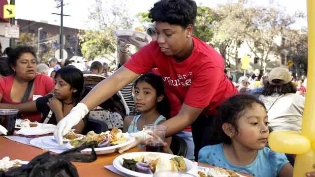 Una voluntaria entrega comida en Acción de Gracias a personas sin hogar