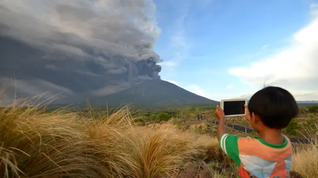 Un niño fotografía el volcán